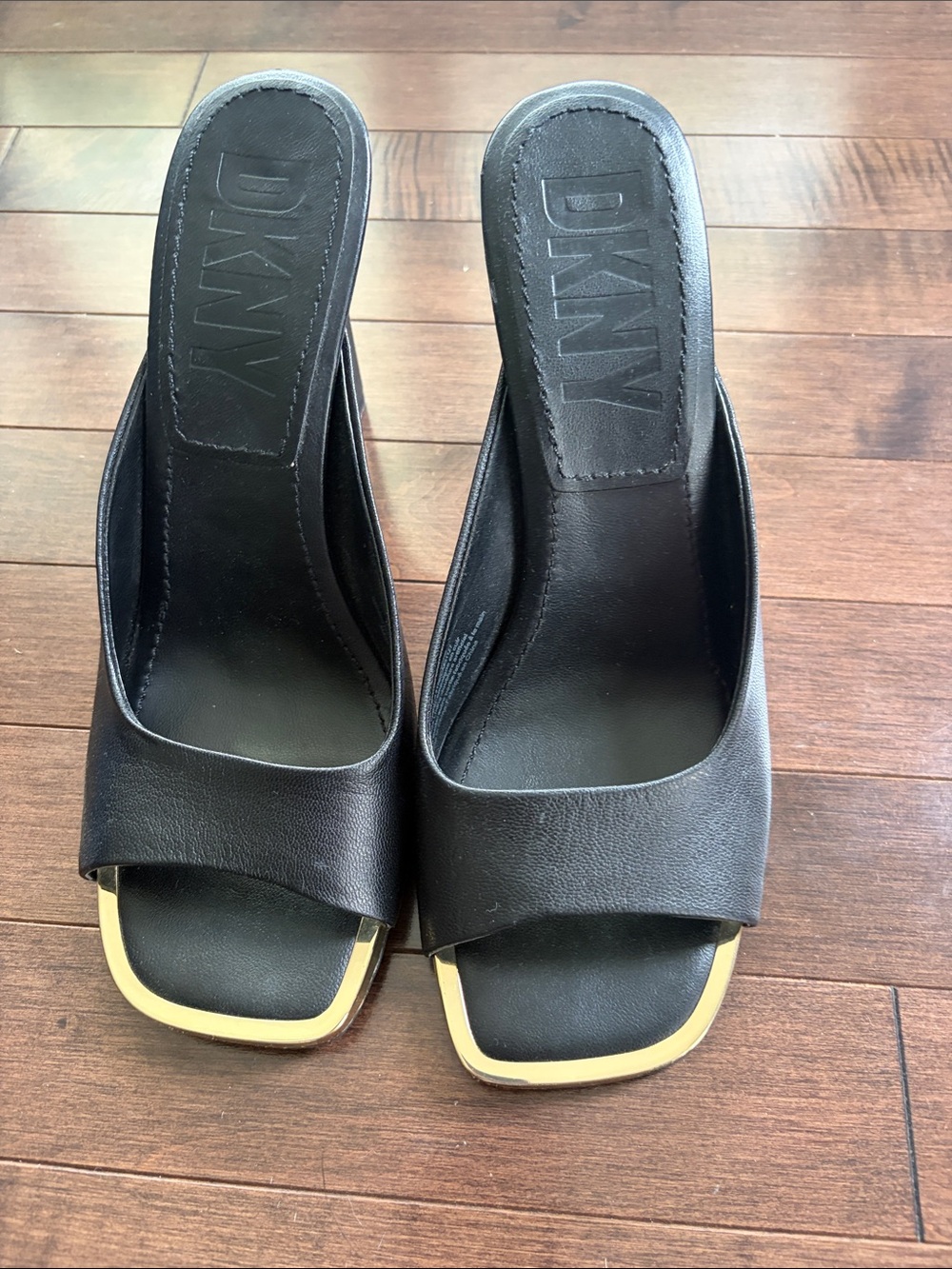 Leather DKNY slides with gold square toe.